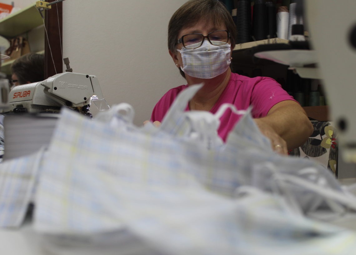 Voluntária confeccionando e fazendo uso da sua própria máscara
Foto: Lilian Moraes