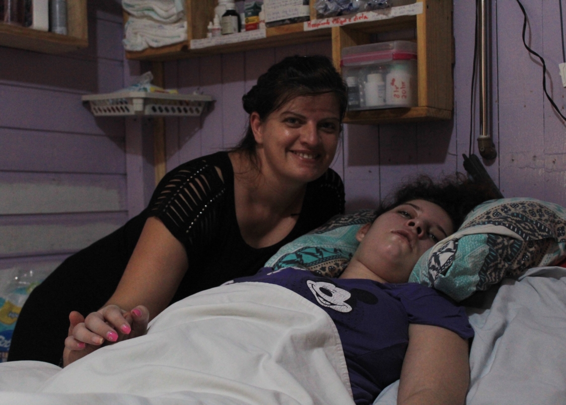 Laci e Jenifer no quarto da jovem, que está acamada 
Foto: Lilian Moraes