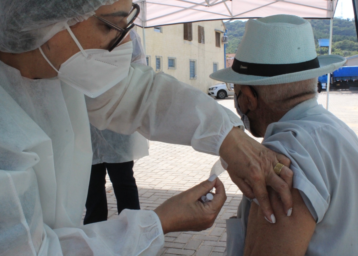 Seu Macedo, de a pé, foi tomar a primeira dose da vacina 
Fotos: Lilian Moraes