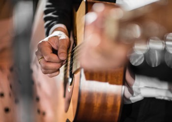 Closeup hand playing acoustic guitar