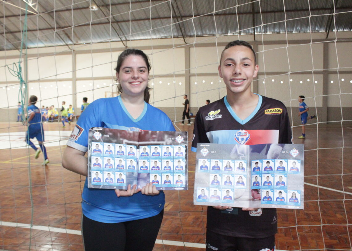 Aluna Júlia, do vôlei, e Pedro, do futsal, com seus álbuns já completos 
Fotos: Lilian Moraes