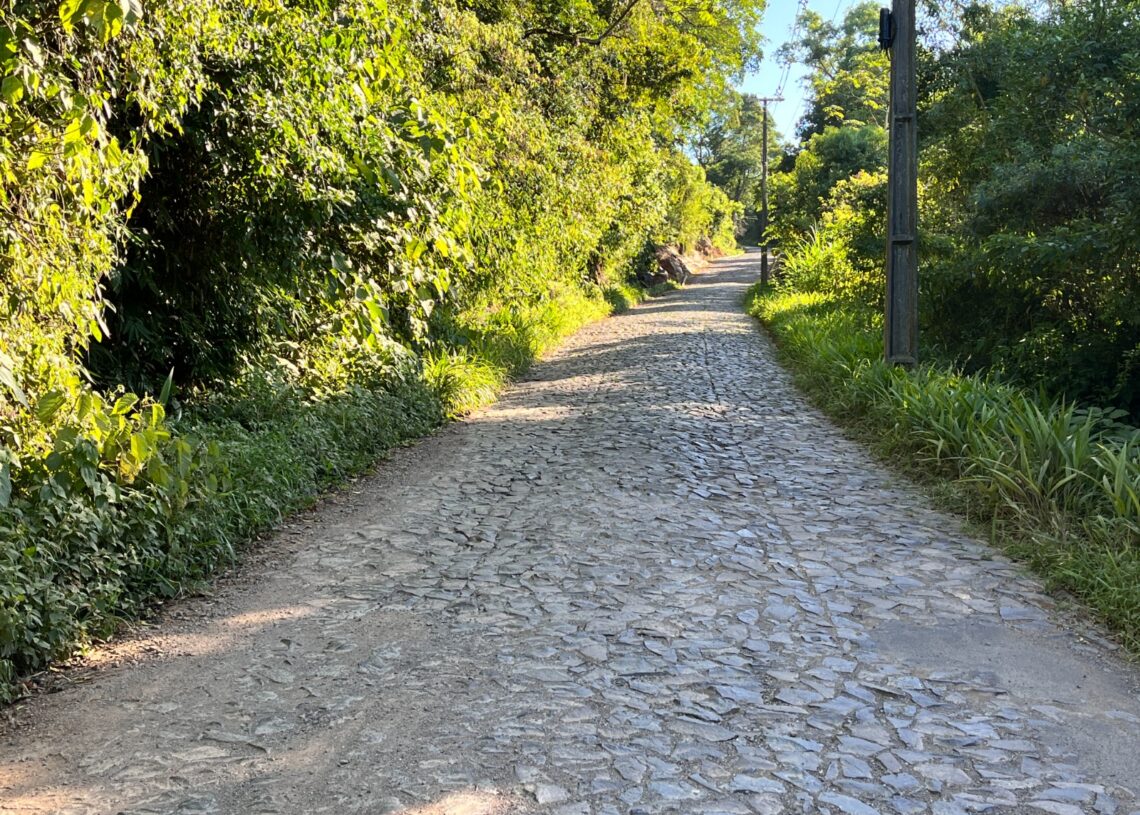 Rua é pavimentada com pedras. Parte do trecho já tem asfalto.
Foto: Matheus de Oliveira